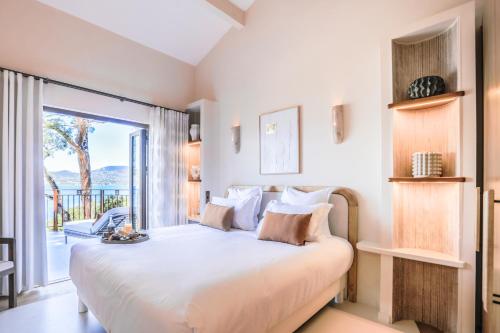 a bedroom with a large bed and a large window at Tinah Saint-Tropez in Saint-Tropez