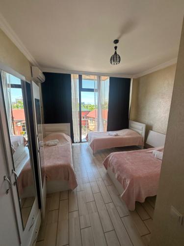 a hotel room with two beds and a mirror at My House in Batumi