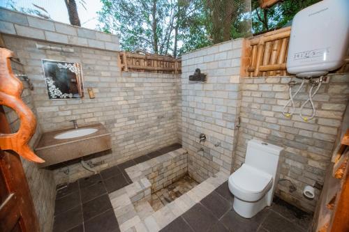 a bathroom with a toilet and a sink at Bagaicha Adventure Resort in Maruwā Ghāt