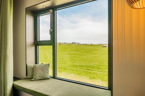 a window seat with a view of a green field at das flax allgäu in Dietmannsried