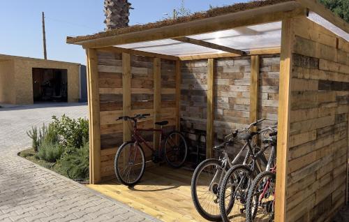 dos bicicletas están estacionadas en un cobertizo de madera en Chalé do Vale, en Pinhal Novo