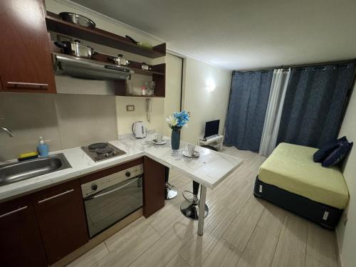 una piccola cucina con tavolo e lavandino di Apartamentos Orquídea Suite a Santiago