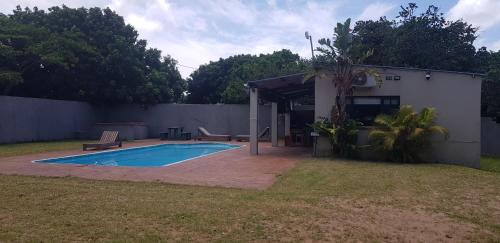 a small swimming pool in a yard next to a building at Ohana Pool Cottage in Ponta do Ouro