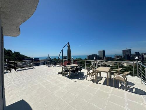a patio with tables and chairs on top of a building at My House in Batumi