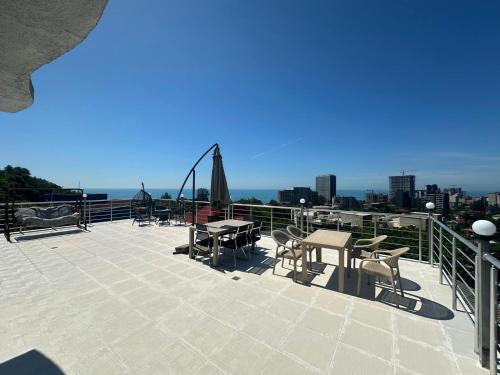 a patio with tables and chairs on a roof at My House in Batumi