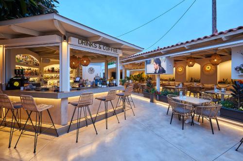 a restaurant with tables and chairs and a bar at Mila Malia Studios Hotel in Malia