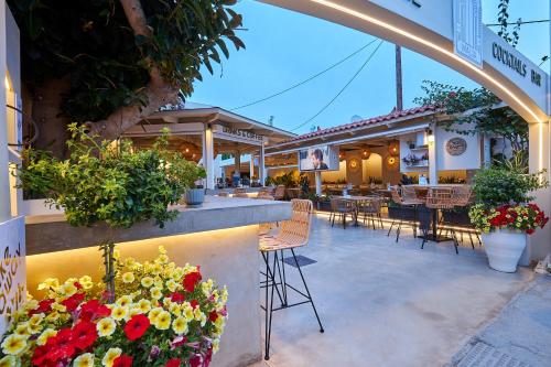 a restaurant with a bar with flowers and tables at Mila Malia Studios Hotel in Malia
