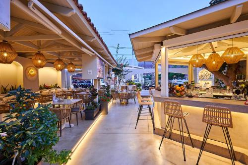 a restaurant with chairs and tables and a bar at Mila Malia Studios Hotel in Malia