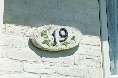 a sign on the side of a brick wall at Entire Bungalow between Sea and National Park in East Preston