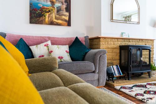 a living room with a couch and a fireplace at Entire Bungalow between Sea and National Park in East Preston