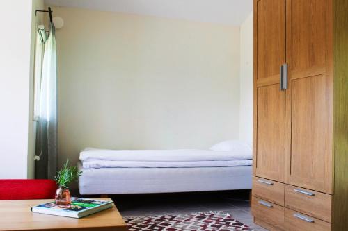 a bedroom with a bed and a wooden cabinet at Skårs gård in Fjärås