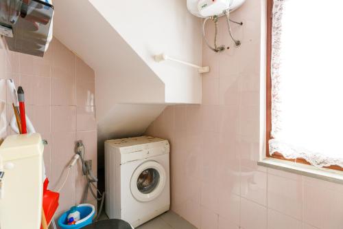 a small bathroom with a washing machine in a room at Villetta Macchia Mediterranea in Cuglieri