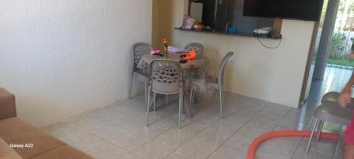 a dining room table with chairs and a television at Casa Residencial Praia do Sossego in Jaguaribe