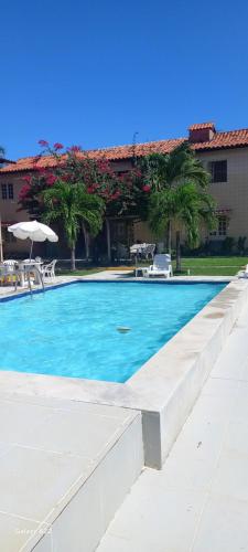 a swimming pool with blue water in front of a building at Casa Residencial Praia do Sossego in Jaguaribe