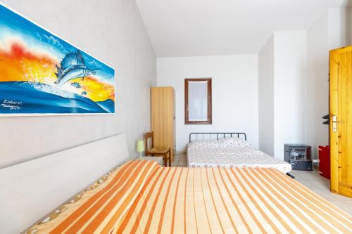 a bedroom with two beds and a painting on the wall at Villetta Macchia Mediterranea in Cuglieri