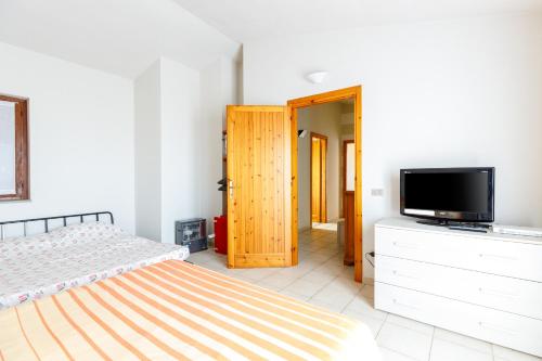 a bedroom with a bed and a flat screen tv at Villetta Macchia Mediterranea in Cuglieri