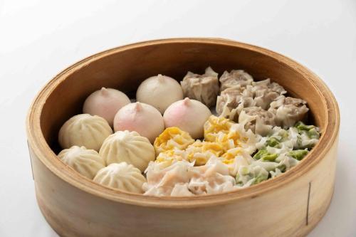 a wooden bowl filled with onions and vegetables at Hotel Associa Shin-Yokohama in Yokohama