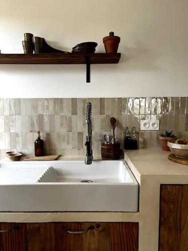 - une cuisine avec un évier blanc dans l'établissement Maison Bacchus, gîte insolite dans cuve à vin, à Caves