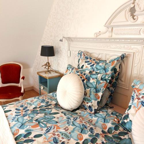a bedroom with a bed with a large pillow on it at Kergroaz Maner Classé 5 épis Table d'Hôtes Manoir dans parc paysagé, spa en plein air Bornes véhicules électriques Petit déjeuner inclus in Yvias