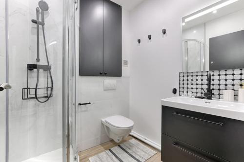 une salle de bain avec une douche, des toilettes et un lavabo dans l'établissement Charming Apartment 1BR in heart of 10th, à Paris