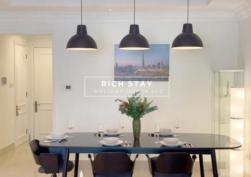 a dining room with a black table and chairs at Upgraded 1BR in Downtown with Burj Khalifa View in Dubai