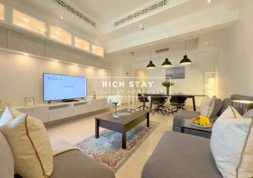 a living room with a couch and a tv at Upgraded 1BR in Downtown with Burj Khalifa View in Dubai