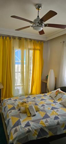 a bedroom with a bed with yellow curtains and a ceiling fan at Perea Silvi suite in Perea