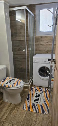 a bathroom with a toilet and a washing machine at Perea Silvi suite in Perea