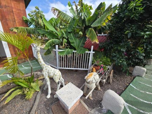 a toy giraffe and an elephant in a garden at Hotel Rural La Raya 1866 in Güimar