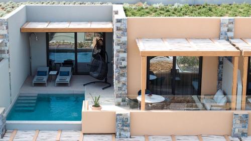 a woman taking a picture of a house with a swimming pool at Cayo Exclusive Resort & Spa in Elounda