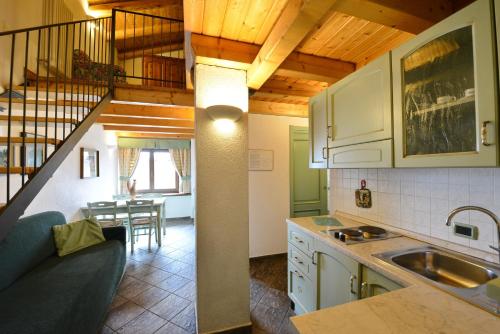 a kitchen and dining room with a staircase in a house at Residence Au Vieux Grenier in Cogne