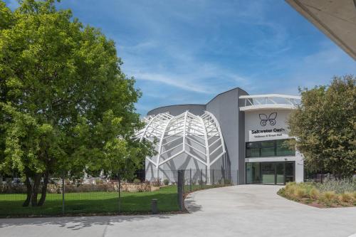 an office building with a curved facade and trees at Camping Homes Mon Perin in Bale