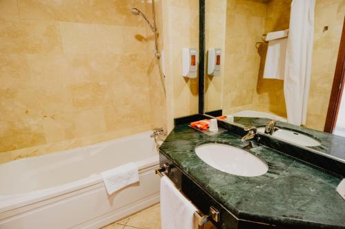 a bathroom with a sink and a bath tub at Hotel Hacienda Don Manuel in Granja de Torrehermosa