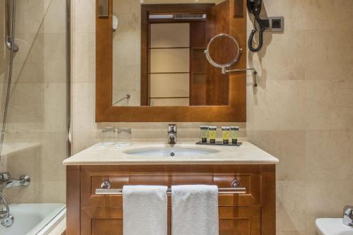 ein Bad mit einem Waschbecken und einem Spiegel in der Unterkunft Eurostars Diana Palace in Palencia