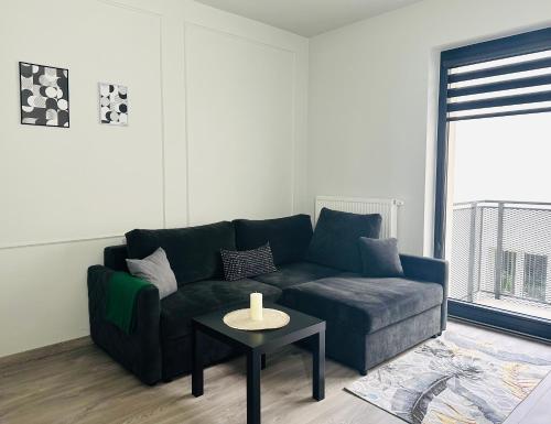 a living room with a blue couch and a table at Małe Garbary 8 Apartment in Poznań