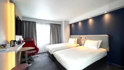 een hotelkamer met 2 bedden en een bureau bij Holiday Inn Express Windsor, an IHG Hotel in Windsor