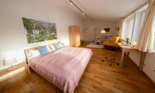 a bedroom with a large bed and a desk and a desk at Gästehaus am Michaelshof, im «Haus der Natur» in Neu Darchau