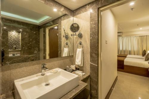1 dormitorio y baño con lavabo. en Ivory Tower en Bangalore