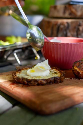 a spoon and a piece of bread with a egg on a cutting board at Skårs gård in Fjärås