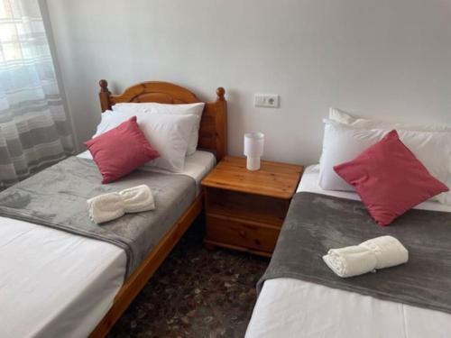 two beds in a room with red and white pillows at Casa Diana in Loja