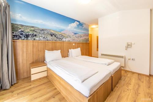una camera da letto con un letto e un dipinto sul muro di Villa Tino a Ohrid
