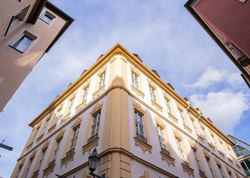 a tall yellow building with windows on top of it at Barockes Wohnen am Marktplatz-Stadtmitte in Würzburg