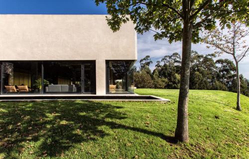 a house on a hill with a tree in the foreground at Hotel Pepe Vieira in Raxo