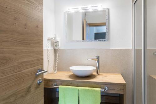 ein Badezimmer mit einem Waschbecken und einem Spiegel in der Unterkunft Landhaus Bergland in Obsteig