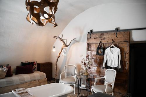 een kamer met een bad en een tafel en stoelen bij Baita nel Borgo Naturas con piscina idromassaggio privata e gratuita in Rossana