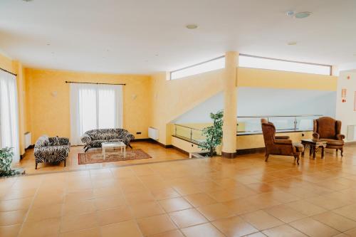 a large living room with chairs and a table at Hotel Hacienda Don Manuel in Granja de Torrehermosa