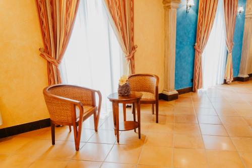a room with two chairs and a table and a window at Hotel Hacienda Don Manuel in Granja de Torrehermosa