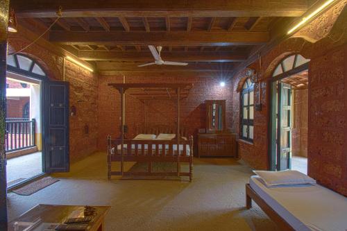 a room with two beds and a ceiling fan at Konkan Nest Resort in Ganpatipule