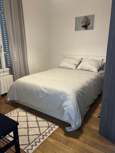 une chambre avec un lit avec une couette blanche dans l'établissement Paris pleyel, à Saint-Denis