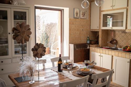 een keuken met een tafel en een fles wijn bij Baita nel Borgo Naturas con piscina idromassaggio privata e gratuita in Rossana